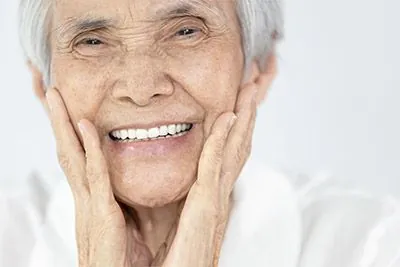 woman smiling after All-on-4® Dental Implants helped restore her smile