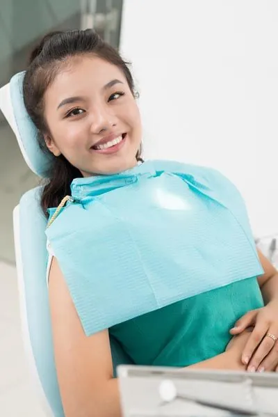 patient showing off her restored smile after getting a dental crown