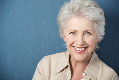 woman with implant-retained dentures smiling