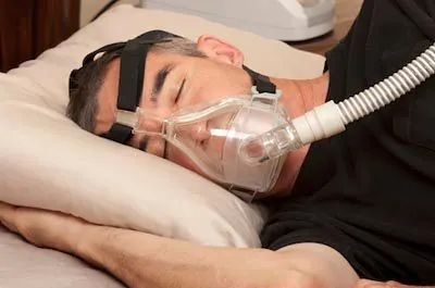 man asleep while using a CPAP machine