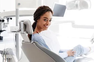 patient sitting in the dental chair after her desensitizing dental treatment helped relieve her sensitive teeth