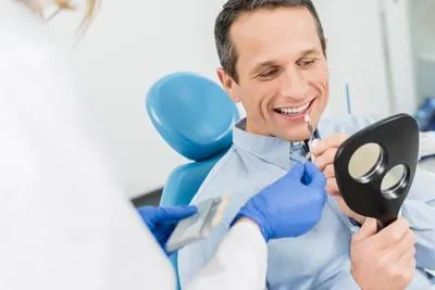 man color matching dental implant shades to his teeth